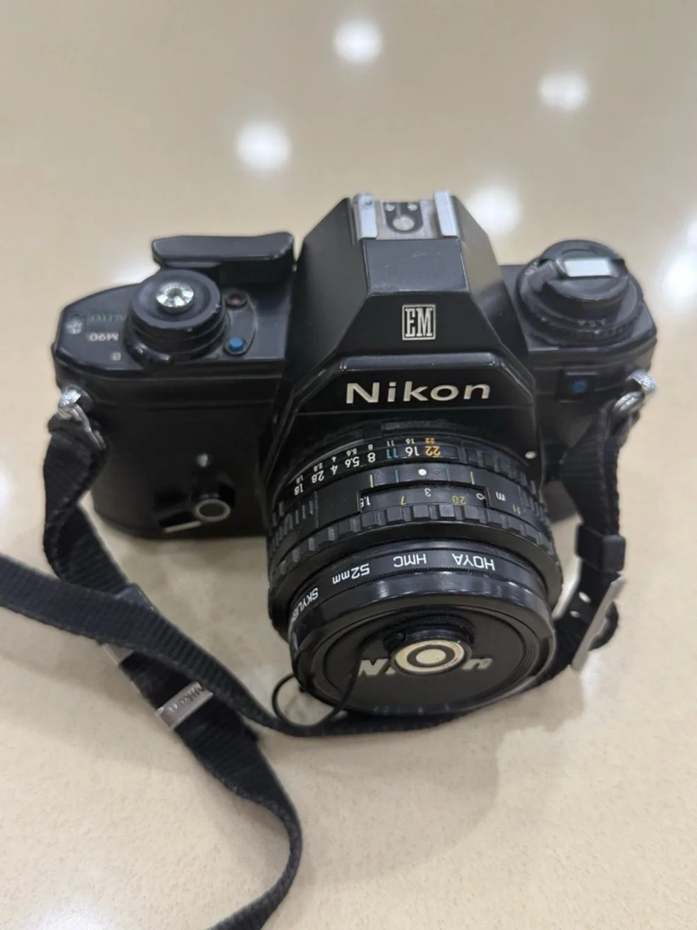 Nikon Black 35mm SLR Camera with Attached Lens and Strap